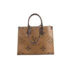 Front view of Louis Vuitton OntheGo MM in brown Giant Monogram Reverse with dark Monogram top handles, long shoulder straps and gold-tone hardware.