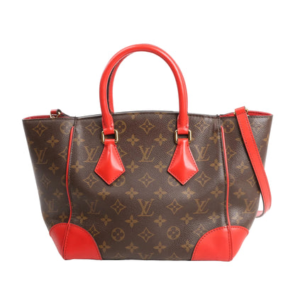 Louis Vuitton Phoenix PM 2-way shoulder bag in brown Monogram canvas, featuring vivid red leather top handles, trim, and corners, with gold-tone hardware and structured silhouette.