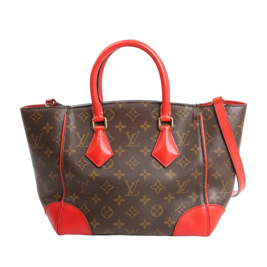 Louis Vuitton Phoenix PM 2-way shoulder bag in brown Monogram canvas, featuring vivid red leather top handles, trim, and corners, with gold-tone hardware and structured silhouette.