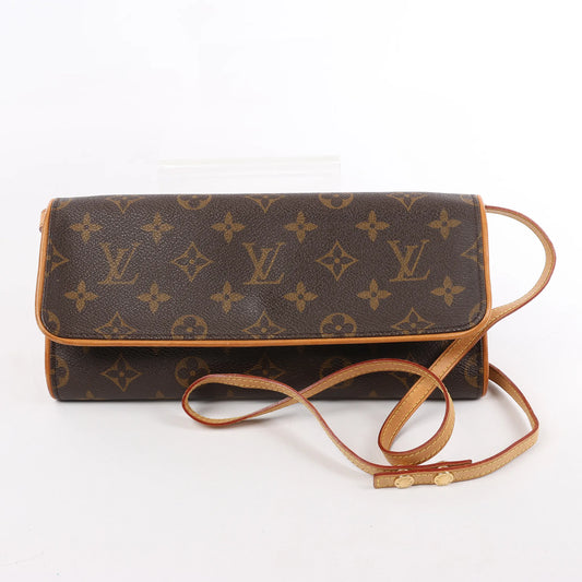 Front view of the Louis Vuitton Monogram Canvas Pochette Twin GM Shoulder Bag M51852, featuring classic brown monogram canvas, natural leather trim, a long adjustable shoulder strap, and flap closure, displayed against a white background.