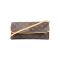 Front view of Louis Vuitton Monogram canvas Pochette Twin GM with tan vachetta leather trim and a long shoulder strap on a white background.