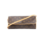Front view of Louis Vuitton Monogram canvas Pochette Twin GM with tan vachetta leather trim and a long shoulder strap on a white background.