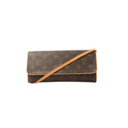 Louis Vuitton Pochette Twin GM crossbody bag in brown Monogram canvas with vachetta leather trim, flap front, and tan leather shoulder strap on white background.