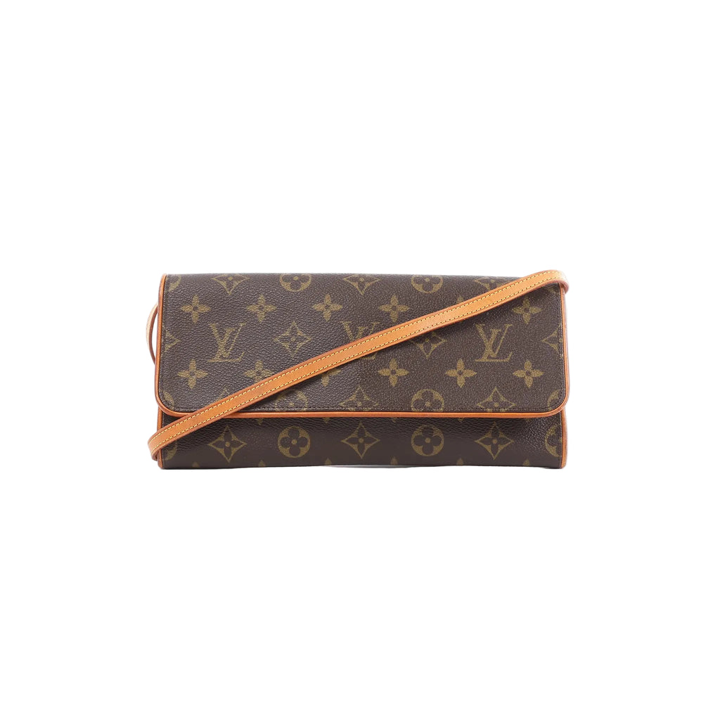 Louis Vuitton Pochette Twin GM Monogram canvas crossbody bag with flap front and vachetta leather trim and strap on white background.