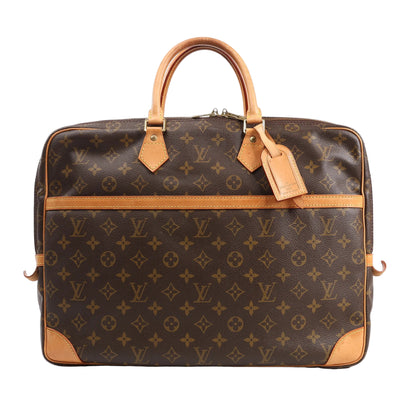 Louis Vuitton Monogram Canvas Porte Documents Voyage Handbag M53362 in brown coated canvas with natural Vachetta leather trim, top handles, front slip pocket, and luggage tag, displayed upright against a white background.