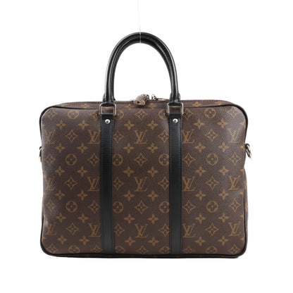 Front view of Louis Vuitton Porte Documents Voyage PM in Monogram Macassar canvas, featuring brown coated canvas with LV monogram pattern, black leather trim and top handles, silver-tone zipper closure, and side D-rings for strap attachment.