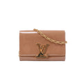 Louis Vuitton glossy beige patent leather clutch with oversized gold-tone LV clasp and rectangular-link chain strap.