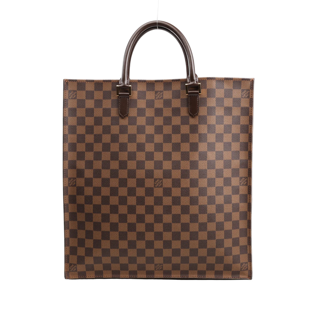 Louis Vuitton Damier Ebene Sac Plat Handbag N51140 featuring brown checkered canvas, dark brown leather top handles, and a flat rectangular shape, displayed standing upright on a white background.