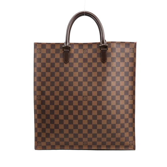 Louis Vuitton Damier Ebene Sac Plat Handbag N51140 featuring brown checkered canvas, dark brown leather top handles, and a flat rectangular shape, displayed standing upright on a white background.