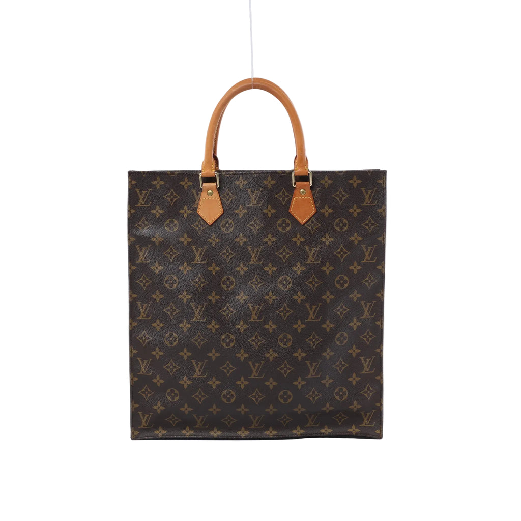 Front view of a tall brown Louis Vuitton Sac Plat Monogram canvas tote bag with two tan leather top handles on a white background.