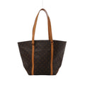 Brown Louis Vuitton Sac Shopping Monogram canvas tote with long tan leather shoulder straps and vertical leather trim, shown front-on against white.