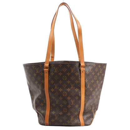 Louis Vuitton Monogram Sac Shopping Shoulder Bag M51108 in classic brown Monogram canvas with natural leather trim and dual long shoulder straps, shown upright against a white background.
