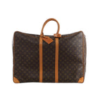 Brown Louis Vuitton Sirius 60 Monogram canvas travel bag with tan leather top handles, vertical trim, corner reinforcements and luggage tag.