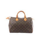Front view of Louis Vuitton Speedy 30 handbag in brown Monogram canvas with vachetta leather top handles, gold-tone zipper, and leather trim.