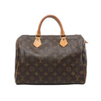 Louis Vuitton Speedy 30 handbag in brown Monogram coated canvas with natural cowhide leather rolled handles, gold-tone hardware, and zip top closure on a white background.