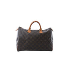 Louis Vuitton Speedy 30 handbag in brown Monogram canvas with tan vachetta leather handles, zip-top closure, and leather zipper pulls on white background.