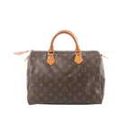 Louis Vuitton Speedy 30 handbag in brown Monogram canvas with natural leather top handles, gold-tone hardware, and zip-top closure on a white background.