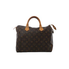 Front view of Louis Vuitton Speedy 30 handbag in brown Monogram canvas with vachetta leather top handles, zip-top closure, and hanging leather clochette with padlock.