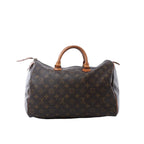 Louis Vuitton Speedy 35 handbag in brown Monogram canvas with tan vachetta leather handles, zip-top closure, and leather zipper pulls on white background.