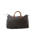 Louis Vuitton Speedy 35 handbag in brown Monogram canvas with tan vachetta leather handles, zip-top closure, and leather zipper pulls on white background.