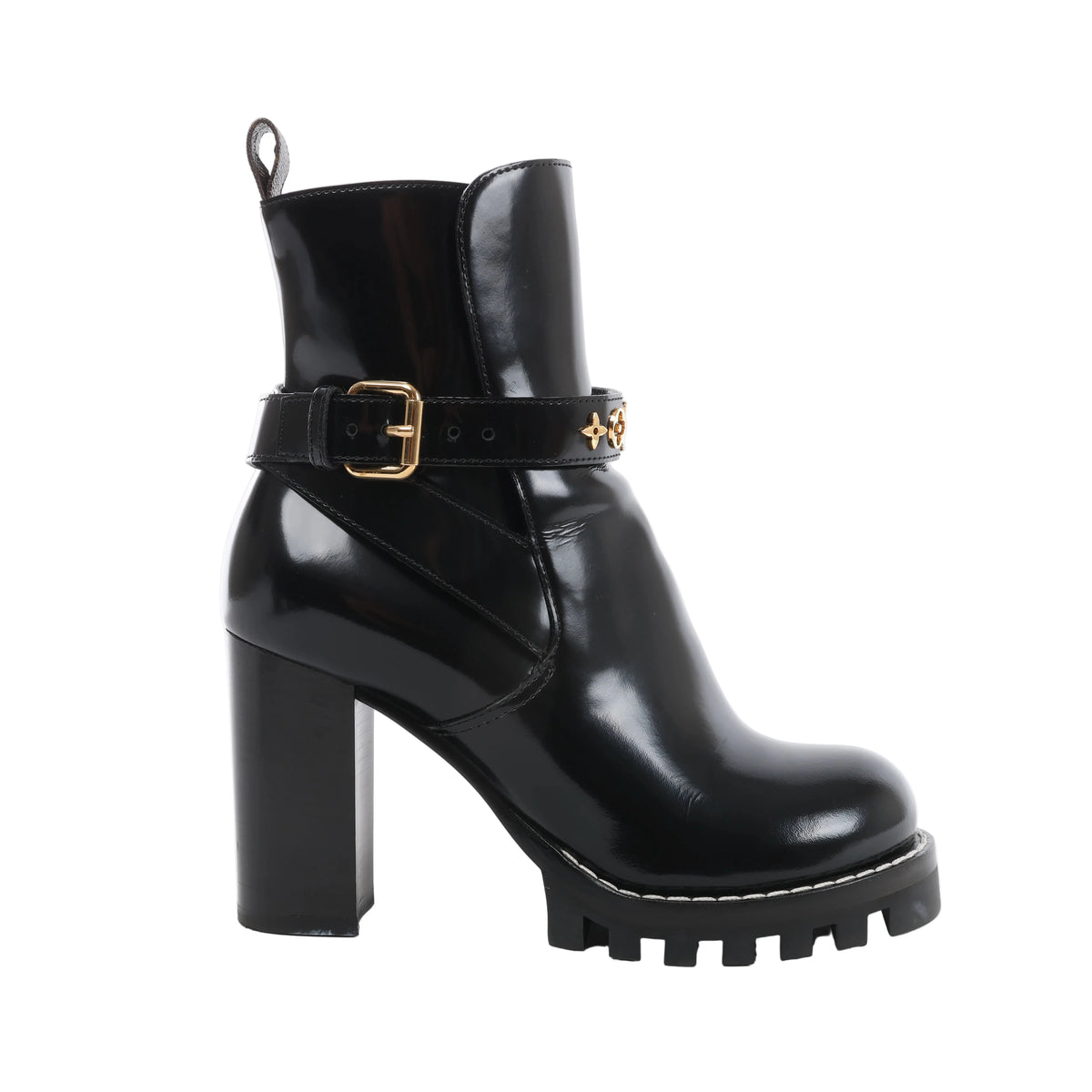 Side view of a black Louis Vuitton Star Trail patent leather ankle boot with a high block heel, cleated platform and gold-tone buckled ankle strap.