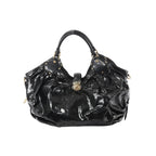 Front view of Louis Vuitton Surya XL bag in black patent Mahina leather with perforated Monogram pattern, ruched body, dual top handles with stud accents, and gold-tone clasp closure.