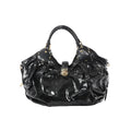 Front view of Louis Vuitton Surya XL bag in black patent Mahina leather with perforated Monogram pattern, ruched body, dual top handles with stud accents, and gold-tone clasp closure.