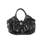Front view of Louis Vuitton Surya XL bag in black patent Mahina leather with perforated Monogram pattern, ruched body, dual top handles with stud accents, and gold-tone clasp closure.