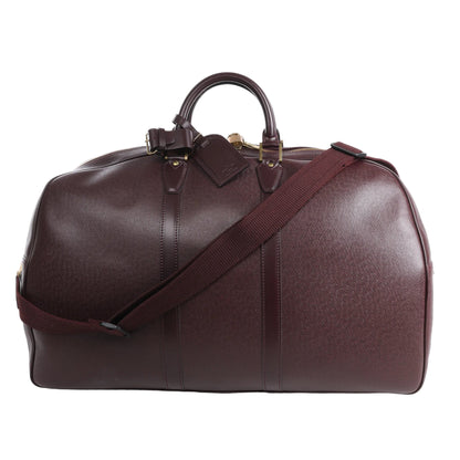 Louis Vuitton Taiga GM Kendall Travel Bag in burgundy leather with fine textured finish, top handles, detachable shoulder strap, gold-tone hardware, and structured duffel silhouette ideal for travel.
