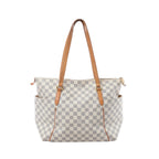 Louis Vuitton Totally MM shoulder bag in beige Damier Azur canvas with tan vachetta leather straps, gold-tone hardware, zip top and side pockets on white background.