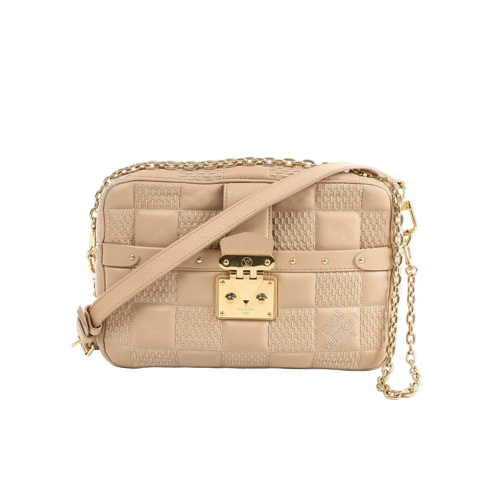 Beige Louis Vuitton Troca MM Damier quilt leather crossbody bag with gold-tone padlock clasp, chain strap detail, and adjustable shoulder strap.
