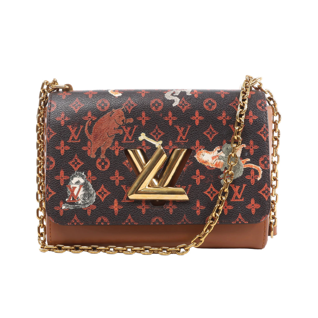 Front view of a Louis Vuitton Twist bag with orange Monogram motifs, illustrated cats and dogs, brown leather trim, a gold-tone LV lock and chain strap.