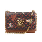 Front view of a Louis Vuitton Twist bag with orange Monogram motifs, illustrated cats and dogs, brown leather trim, a gold-tone LV lock and chain strap.