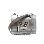 Silver Louis Vuitton Twist PM bag with geometric detailing, a large LV twist lock and a silver-tone chain strap with a brown Monogram shoulder section.