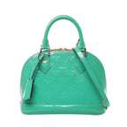 Front view of Louis Vuitton Monogram Vernis Alma BB handbag M90302 in glossy green patent leather, featuring embossed LV monogram, gold-tone hardware, dual top handles, and detachable shoulder strap against a white background.