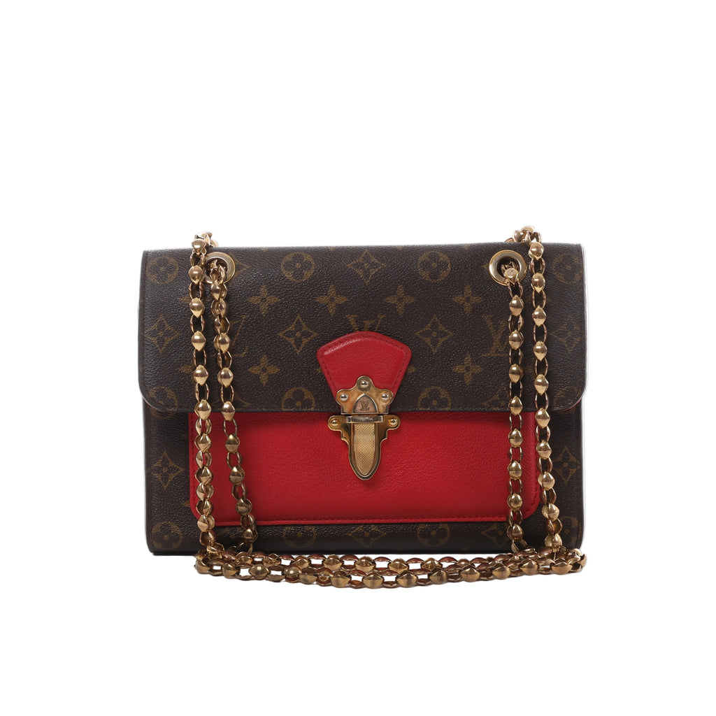 Louis Vuitton Victoire Monogram canvas crossbody bag with red leather front panel, gold-tone clasp and double chain shoulder strap.