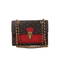 Louis Vuitton Victoire Monogram canvas crossbody bag with red leather front panel, gold-tone clasp and double chain shoulder strap.