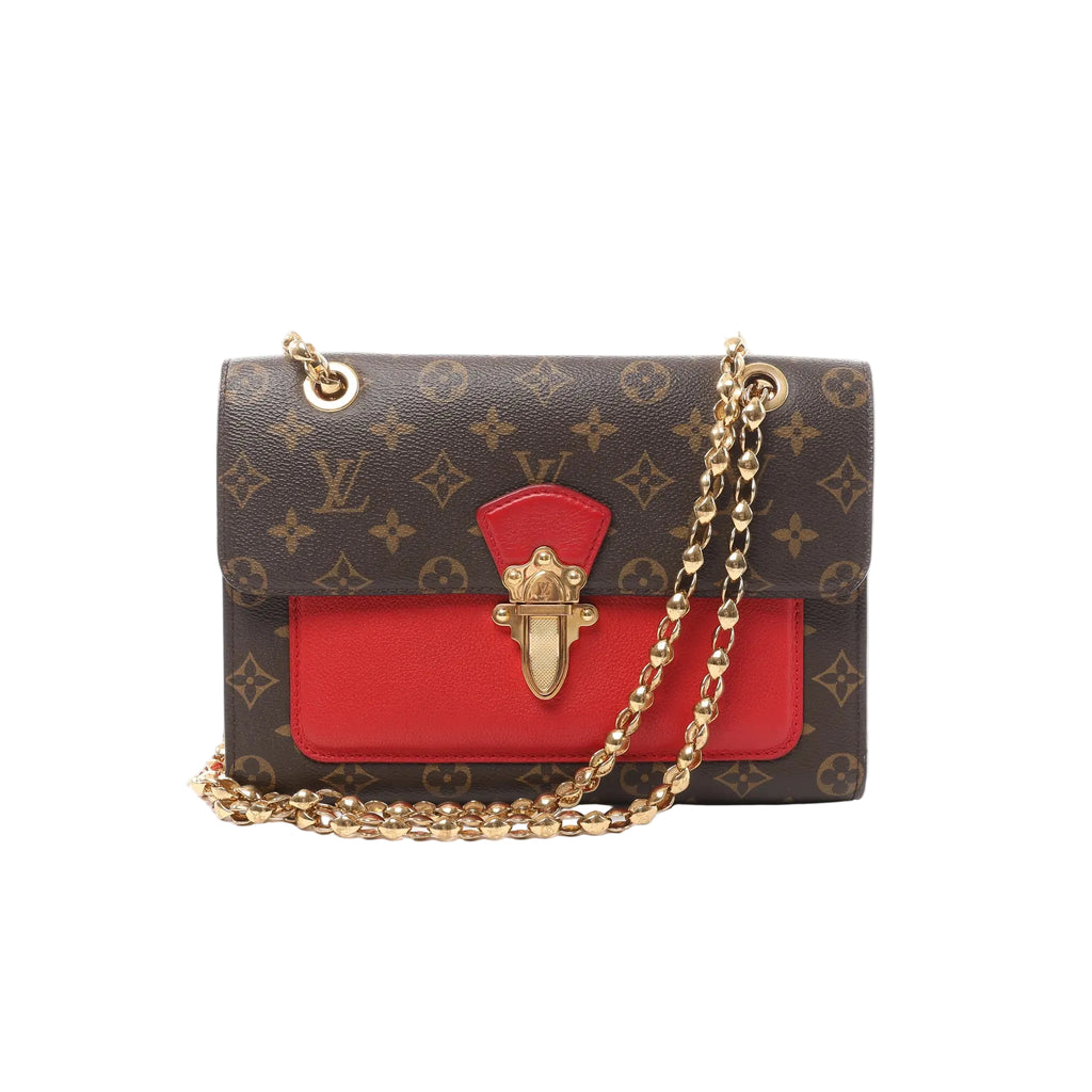 Louis Vuitton Victoire Monogram canvas crossbody bag with red leather front pocket panel, gold-tone S-lock clasp, and gold chain strap, shown on a white background.