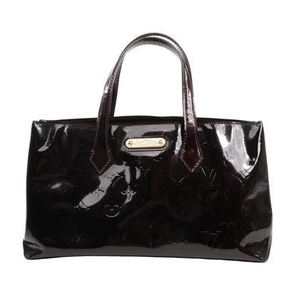 Louis Vuitton Wilshire PM handbag in burgundy Monogram Vernis patent leather with dual handles, gold-tone nameplate, and glossy finish, displayed on a white background.