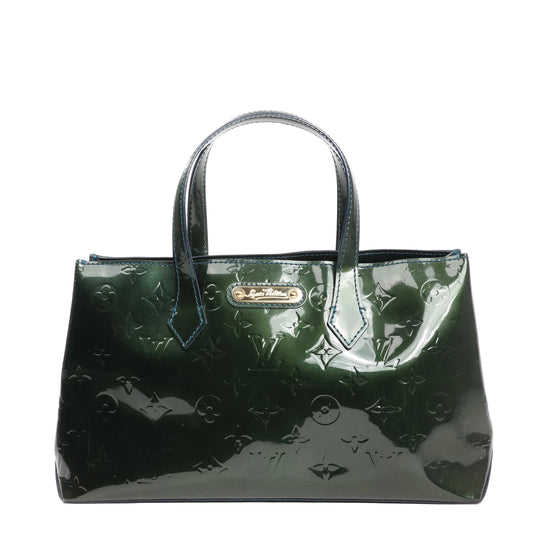 Louis Vuitton Monogram Vernis Wilshire PM Handbag M93684 in shiny green patent leather with embossed Monogram pattern, double top handles, blue-edged stitching, and gold-tone nameplate on the front, standing against a white backdrop.
