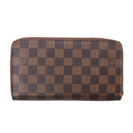 Louis Vuitton Zippy wallet in brown Damier Ebene coated canvas with checkerboard pattern and gold-tone zip-around closure on white background.