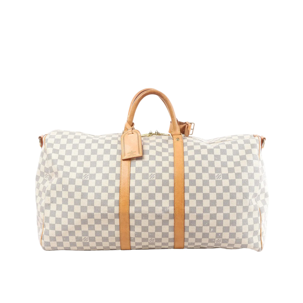 Louis Vuitton Damier Azur Keepall 55 travel bag with tan leather handles, vertical leather straps, luggage tag, and top zip on white background (shoulder strap not shown)