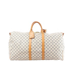 Louis Vuitton Damier Azur Keepall 55 travel bag with tan leather handles, vertical leather straps, luggage tag, and top zip on white background (shoulder strap not shown)