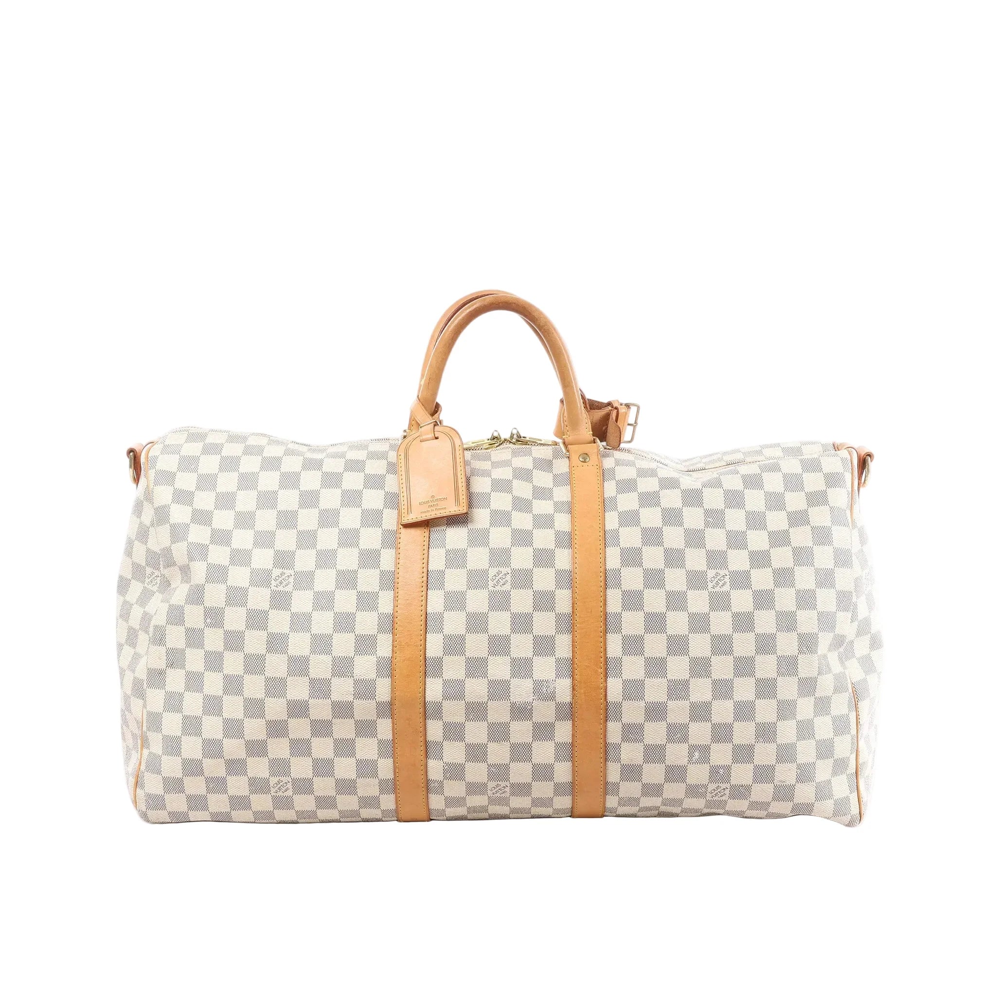Louis Vuitton Damier Azur Keepall 55 travel bag with tan leather handles, vertical leather straps, luggage tag, and top zip on white background (shoulder strap not shown)