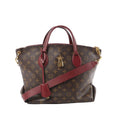 Louis Vuitton Monogram canvas Flower MM tote bag with burgundy leather top handles and crossbody strap, gold-tone hardware, and padlock charm on front.