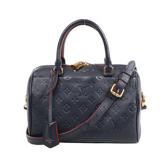 Louis Vuitton Monogram Empreinte Speedy 25 Bandoulière 2Way Handbag in navy blue grained leather with embossed monogram pattern, gold-tone hardware, top handles, adjustable shoulder strap, and red trim, displayed against a white background.