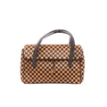 Louis Vuitton Lionne Damier Sauvage pony-style handbag in brown checkered pattern with dark leather top handles, front flap, and a central leather strap with small gold-tone square charm, shown on a white background.