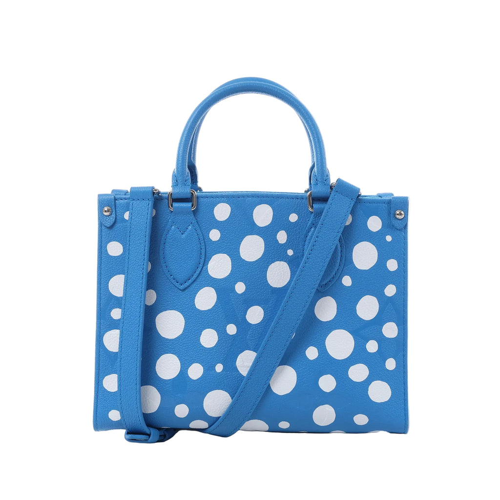 Louis Vuitton x Yayoi Kusama OnTheGo PM blue Empreinte leather handbag with white polka dots, top handles, and shoulder strap on white background.
