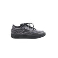 Maison Margiela x Reebok Club C black leather sneaker with black laces, stitched panel design, Reebok side logo, and black rubber sole, side view on white background