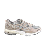 Side view of a grey and taupe New Balance sneaker with mesh panels, textured overlays, a large N logo, toggle laces and a cream midsole.